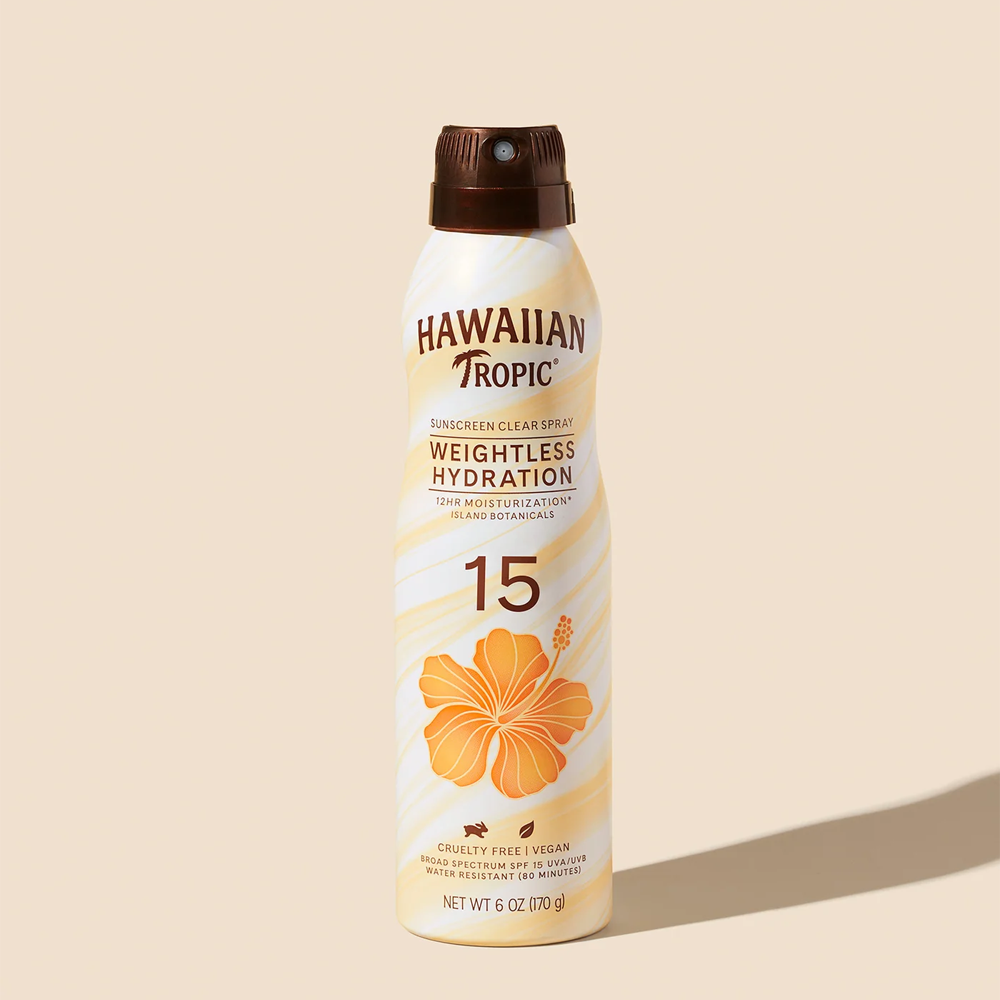 Butelka sprayu do opalania z napisem \'Hawaiian Tropic Weightless Hydration 15\'. Na opakowaniu widoczny jest pomarańczowy kwiat i informacje o właściwościach produktu, takich jak \'Cruelty Free\', \'Vegan\' oraz \'Water Resistant\'.