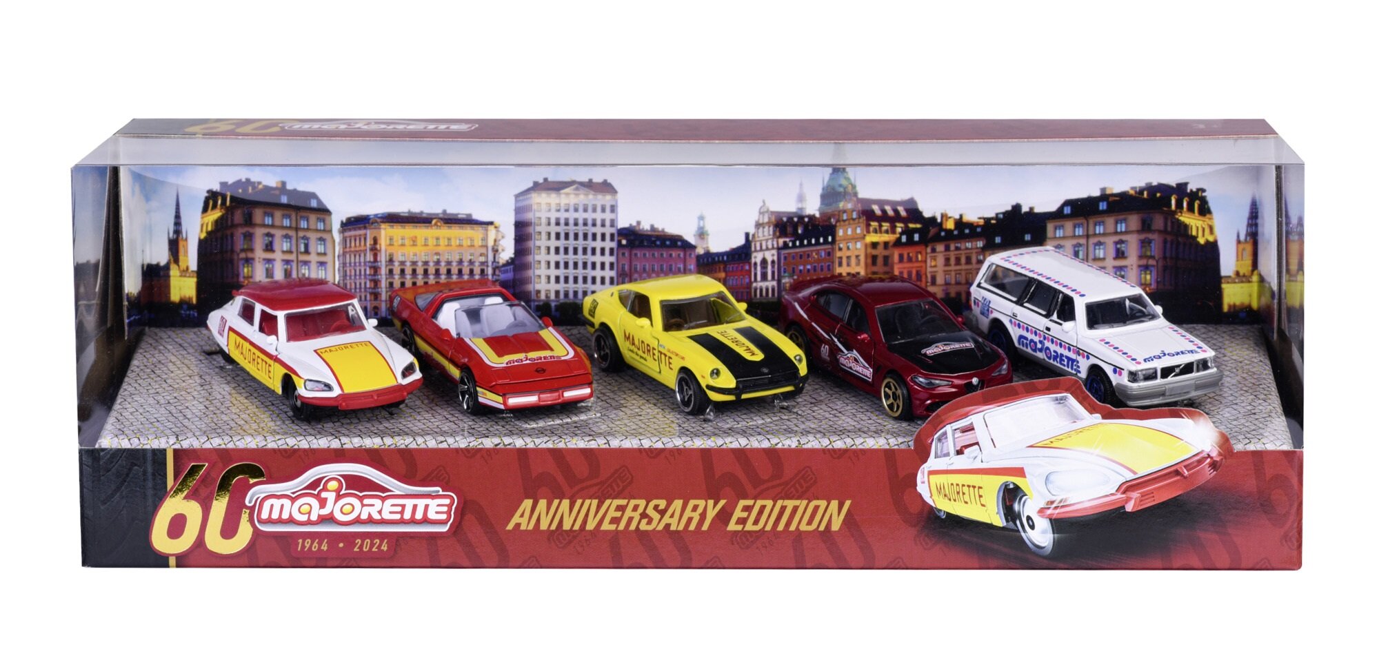 Zestaw pięciu metalowych modeli samochodów w skali 1:64 w opakowaniu z napisem \'Majorette 60th Anniversary Edition 1964-2024\'. W tle widoczna jest panorama miasta z budynkami.