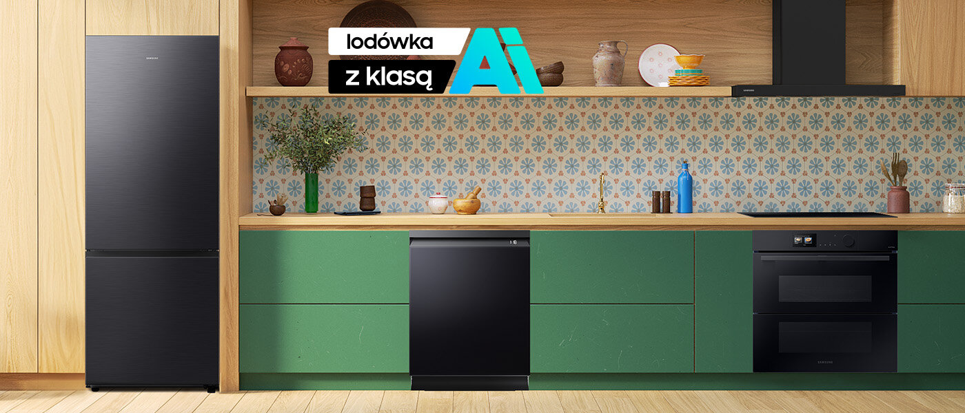rb53dg706ab1 ai 1400x600 new Kuchnia z zielonymi szafkami, na których stoi kilka naczyń i dekoracji. Po lewej stronie znajduje się czarna lodówka, a na środku widoczny jest napis \'lodówka z klasą AI\'.