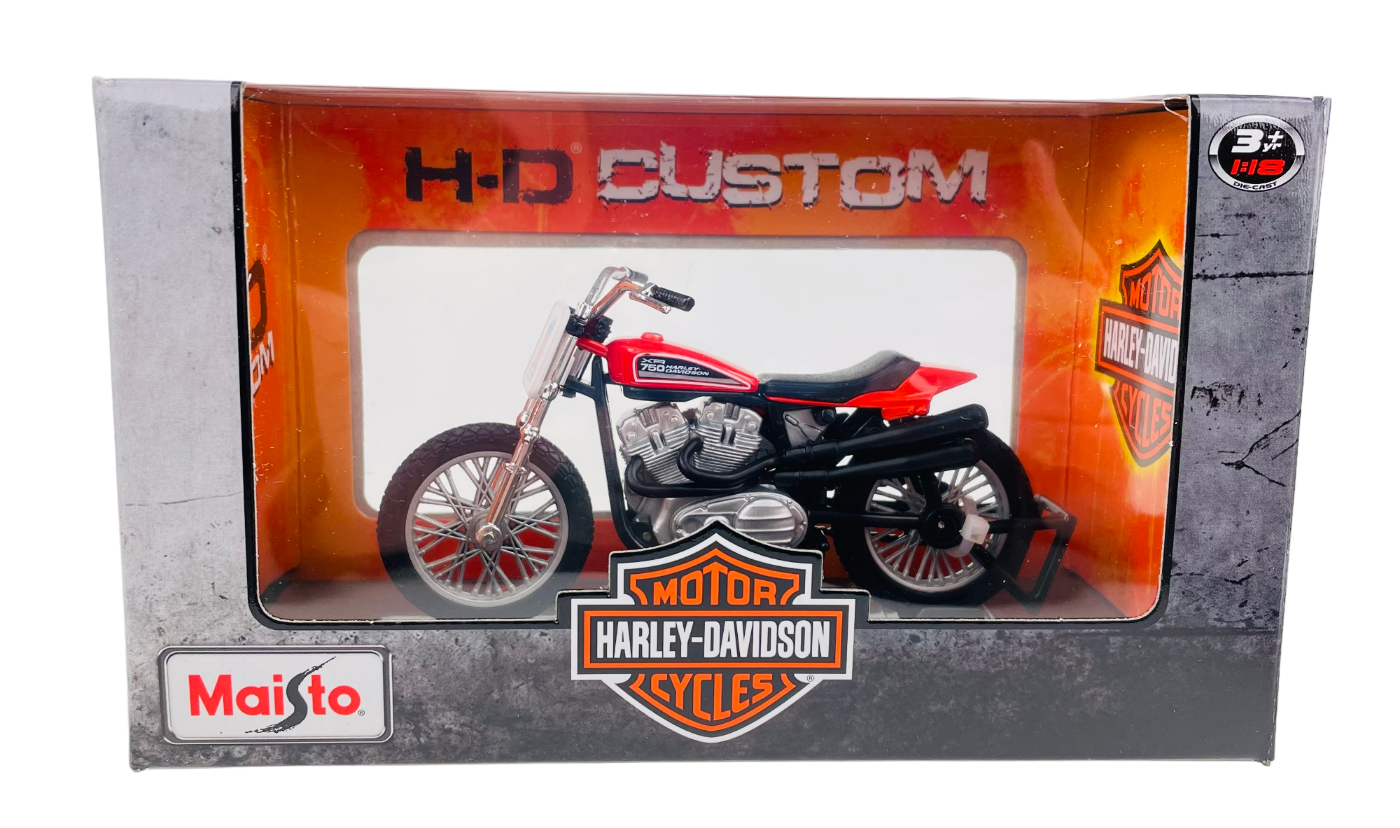 Model motocykla w skali 1:18 w opakowaniu z napisem \'H-D Custom\' i logo \'Harley-Davidson Motor Cycles\'. Widoczne logo \'Maisto\' na opakowaniu.