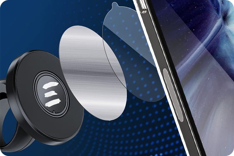 Obraz przedstawia magnetyczny uchwyt na telefon z elementami montażowymi, w tym metalową płytką i przezroczystą osłoną. W tle widoczny jest fragment telefonu z wyświetlaczem.