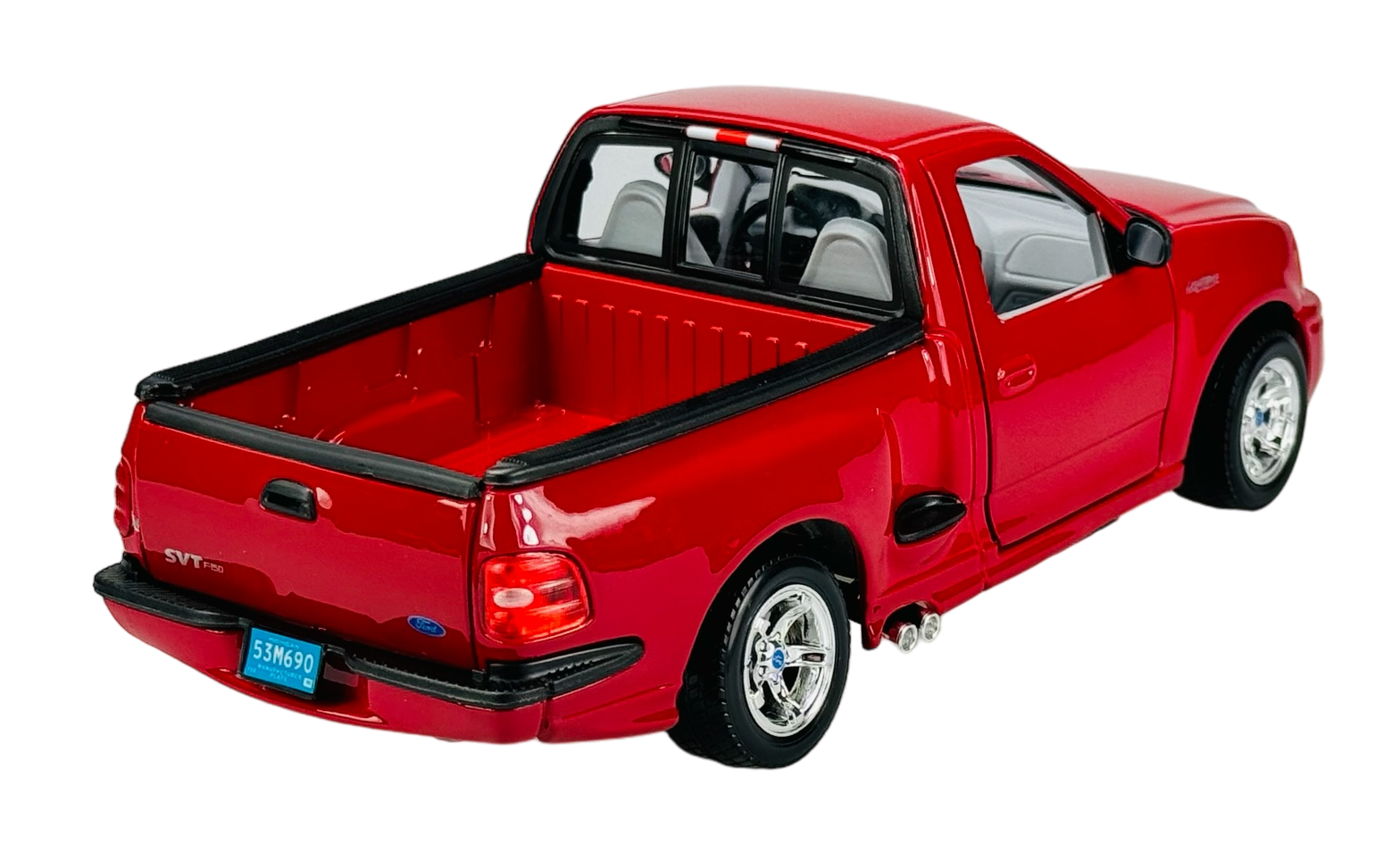 Czerwony model samochodu typu pickup z otwartą przestrzenią ładunkową i widocznymi detalami, takimi jak lusterka boczne i felgi. Na tylnej klapie widoczne są oznaczenia \'SVT\' oraz tablica rejestracyjna z numerem \'53M690\'.