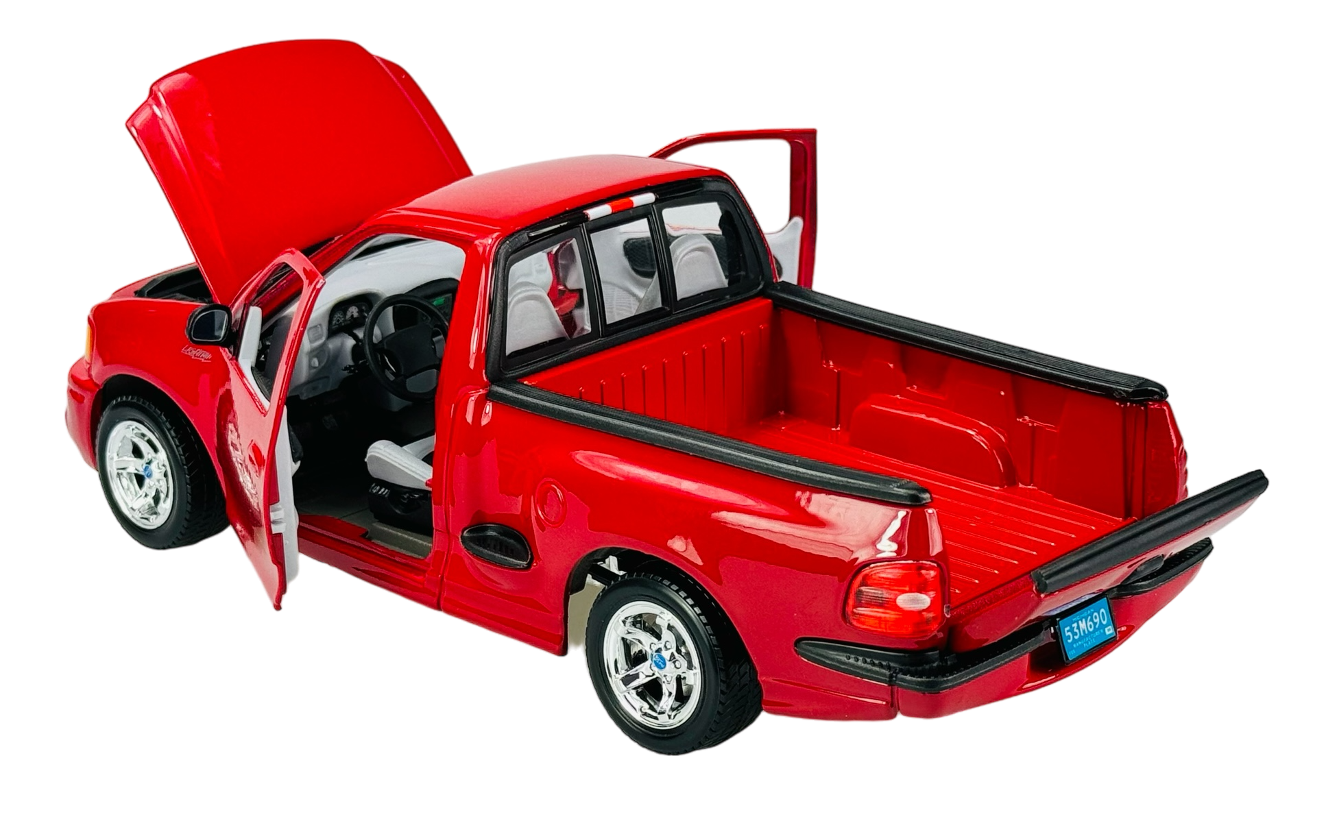 Czerwony model samochodu typu pickup z otwartymi drzwiami i maską. Wnętrze kabiny oraz przestrzeń ładunkowa są widoczne.