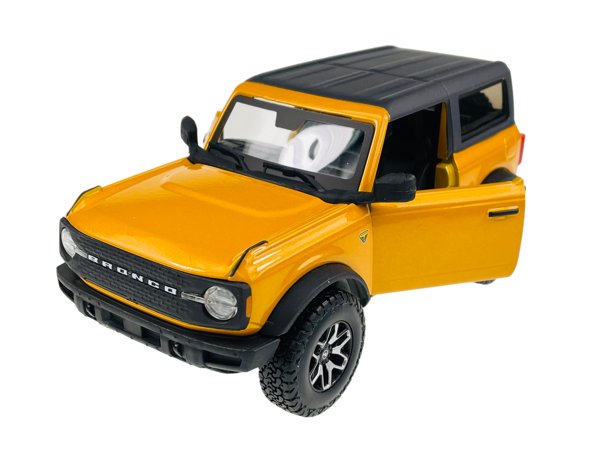 Model samochodu w kolorze pomarańczowym z otwartymi drzwiami i czarnym dachem. Na przodzie widoczny jest napis \'BRONCO\'.