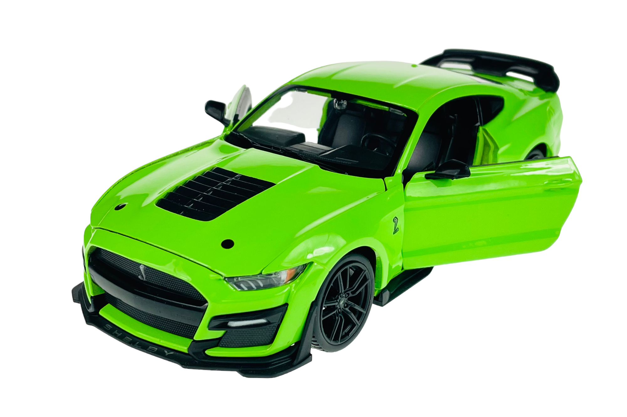 Zielony model samochodu sportowego z otwartymi drzwiami i widocznymi szczegółami wnętrza. Na przednim zderzaku widoczny napis \'SHELBY\'.