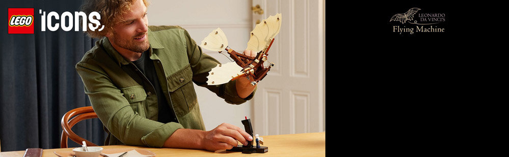 Osoba trzyma model maszyny latającej z jasnymi skrzydłami, siedząc przy stole. W lewym górnym rogu widoczne jest logo \'LEGO icons\', a po prawej napis \'LEONARDO DA VINCI\'S Flying Machine\'.