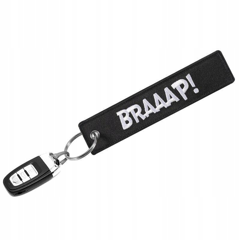 Czarny brelok z napisem \'BRAAAP!\' w białym kolorze, przymocowany do metalowego kółka z kluczykiem samochodowym.