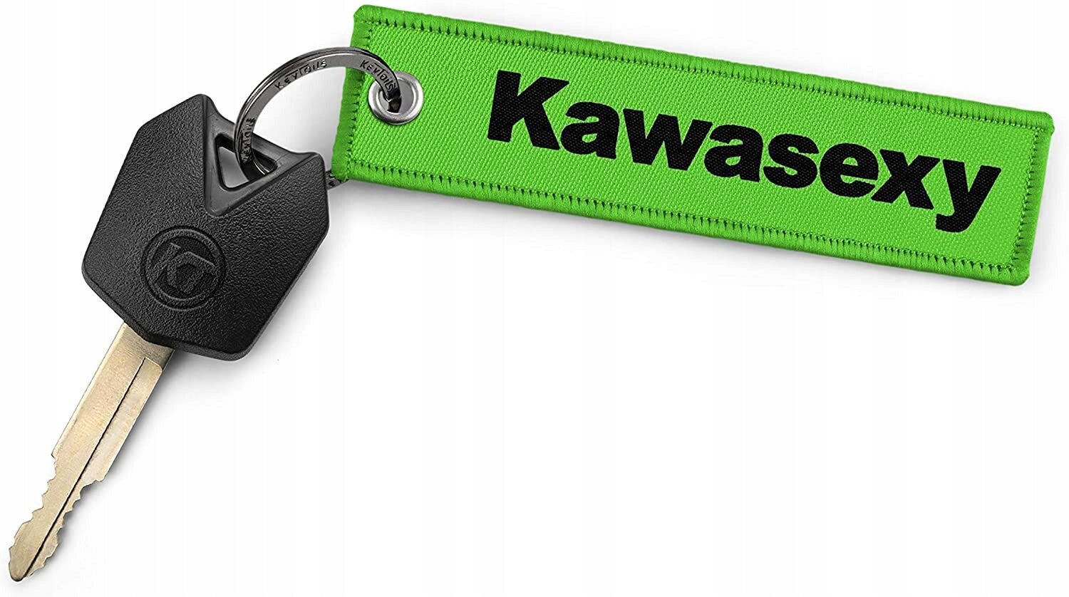 Na obrazie znajduje się klucz z czarną plastikową główką, do którego przymocowany jest zielony brelok z napisem \'Kawasexy\'.