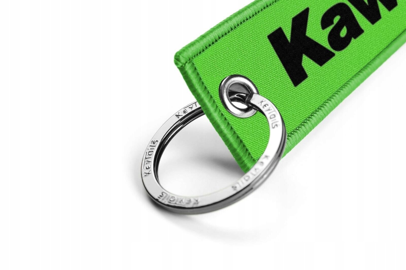 Zielony brelok z czarnym napisem \'Kawasaki\', przymocowany do metalowego kółka z wygrawerowanym tekstem \'KEYTAGS\'.