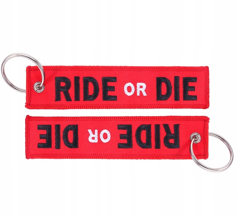 Dwa czerwone breloki z napisem \'RIDE OR DIE\' w kolorze czarnym i białym, każdy z metalowym kółkiem do kluczy.