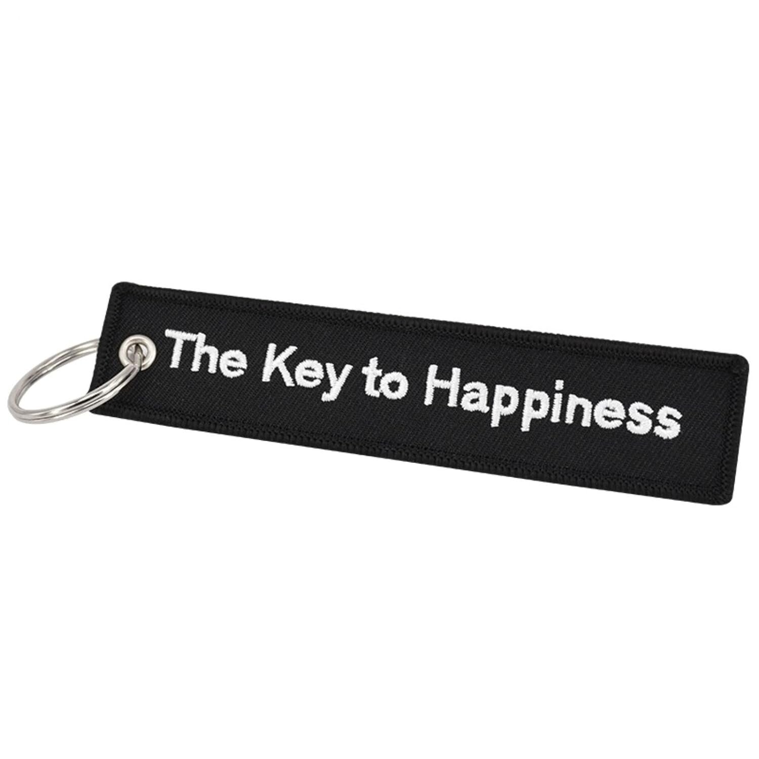Czarny brelok do kluczy z białym napisem \'The Key to Happiness\'.