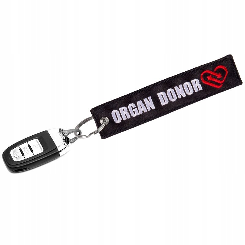 Czarny brelok z napisem \'ORGAN DONOR\' i czerwonym symbolem serca, przymocowany do kluczyka samochodowego.