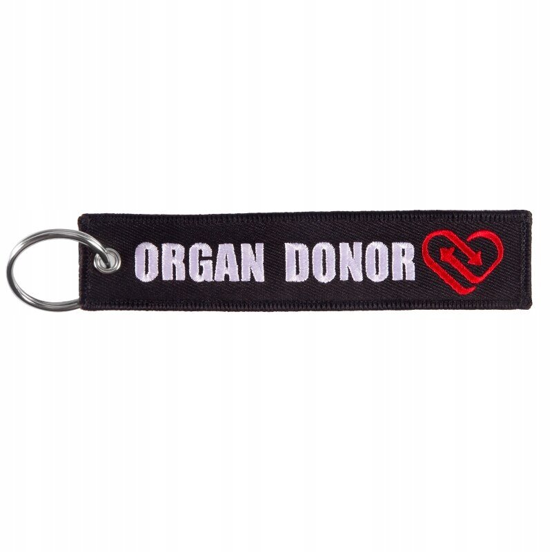 Czarny brelok z napisem \'ORGAN DONOR\' i czerwonym symbolem serca z dwoma strzałkami. Posiada metalowe kółko do zawieszenia kluczy.