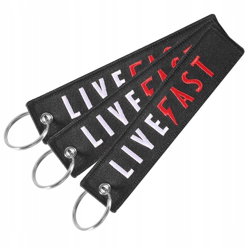Trzy czarne breloki z napisem \'LIVE FAST\' w kolorach białym i czerwonym, każdy z metalowym kółkiem do kluczy.