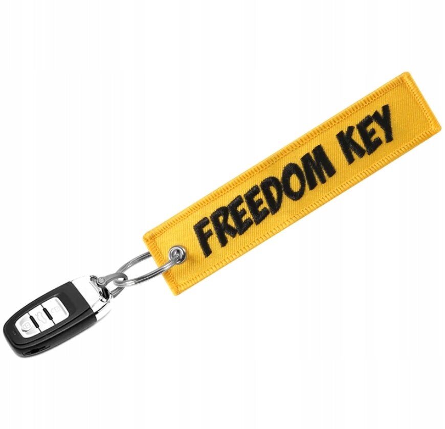 Żółty brelok z napisem \'FREEDOM KEY\' przymocowany do kluczyka samochodowego.