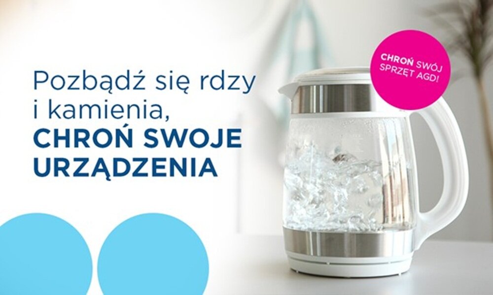 Na obrazie widoczny jest przezroczysty czajnik elektryczny z gotującą się wodą. Obok znajduje się tekst: \'Pozbądź się rdzy i kamienia, CHROŃ SWOJE URZĄDZENIA\'.