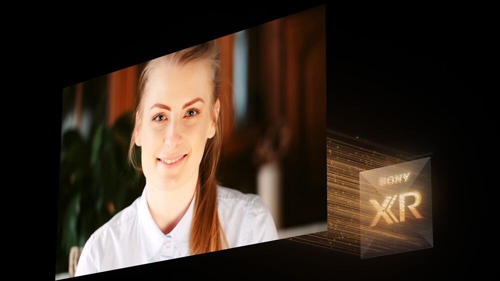 Obraz przedstawia ekran telewizora z wyświetlonym wizerunkiem uśmiechniętej osoby. Obok ekranu widoczne jest logo \'SONY XIR\'.