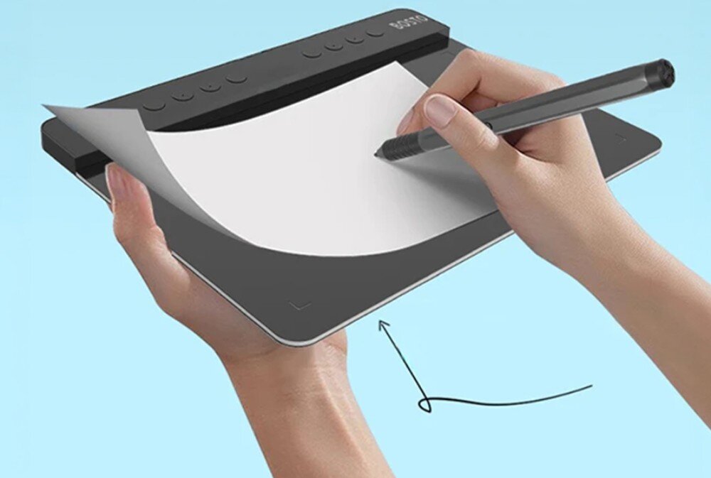 Osoba trzyma tablet graficzny z kartką papieru i rysuje na nim piórem. Na tablecie widoczne jest logo \'BOSTO\'.