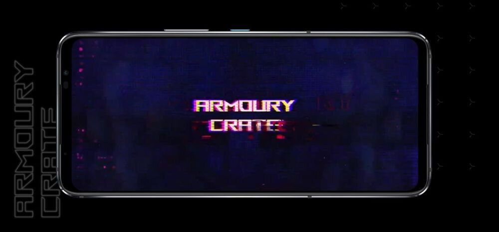 Na ekranie smartfona wyświetlany jest tekst \'ARMOURY CRATE\' na ciemnym tle. Po lewej stronie widoczny jest pionowy napis \'ARMOURY CRATE\'.