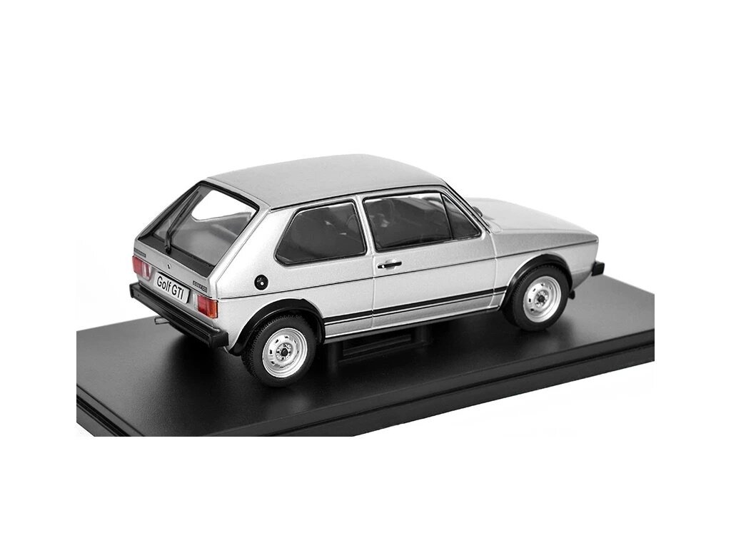Srebrny model samochodu Volkswagen Golf 1 GTI w skali 1:24, umieszczony na czarnej podstawce. Na tablicy rejestracyjnej widnieje napis \'Golf GTI\'.