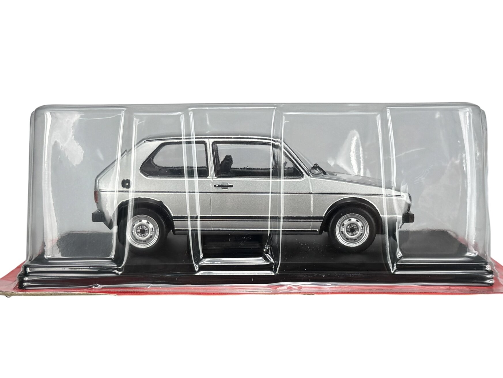 Srebrny model samochodu w skali 1:24, przedstawiający VW Volkswagen Golf 1 GTI z 1976 roku, zapakowany w przezroczyste opakowanie ochronne.