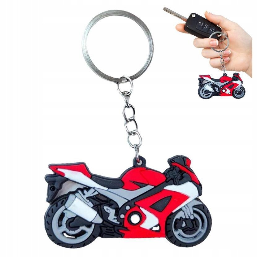 Na zdjęciu widoczny jest brelok do kluczy w kształcie czerwonego motocykla sportowego, przymocowany do metalowego kółka. W tle widać rękę trzymającą klucze z tym samym brelokiem.