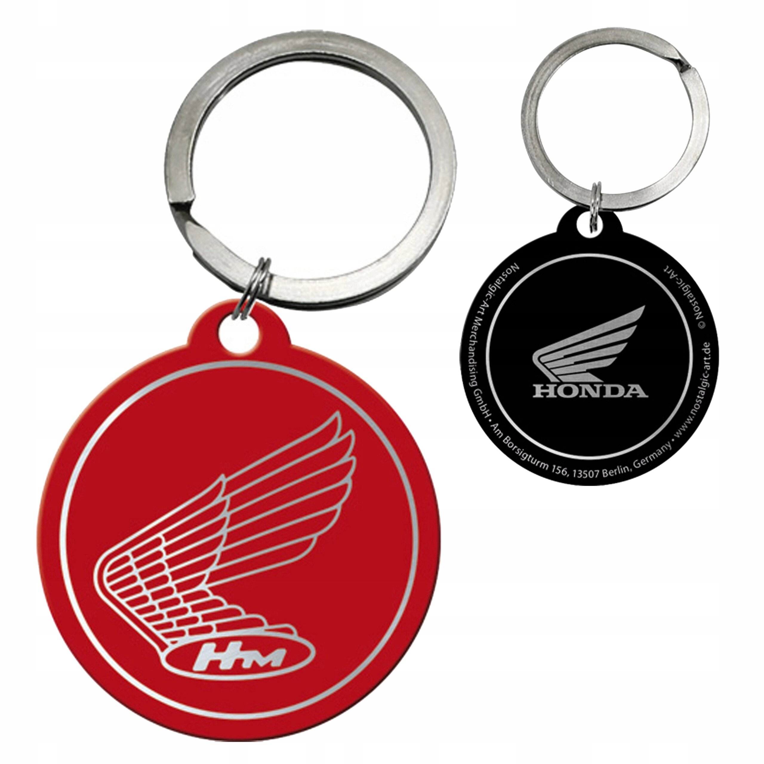Dwa metalowe breloki do kluczy z logo Honda, jeden czerwony z napisem \'HM\', drugi czarny z napisem \'HONDA\'.
