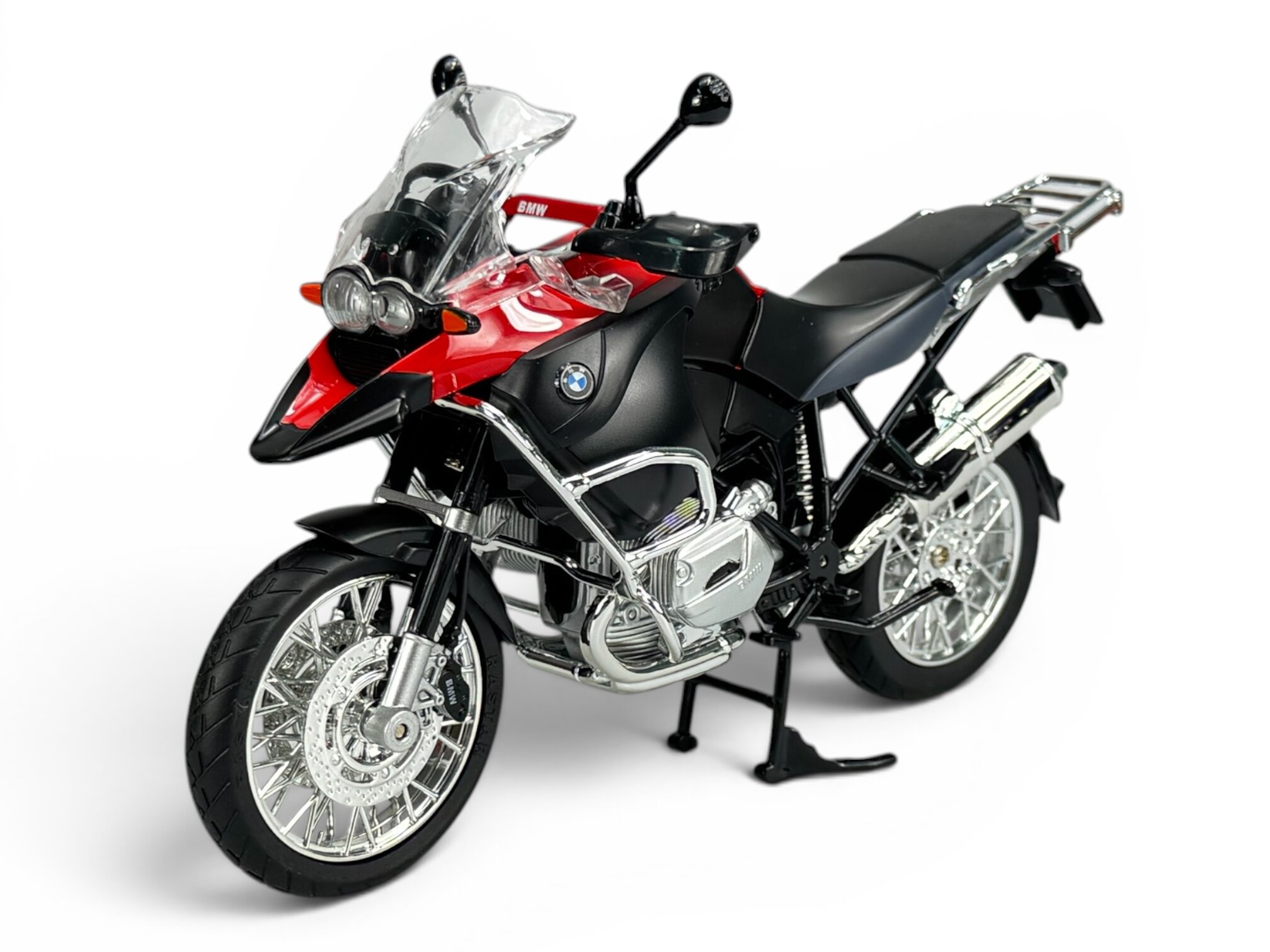Model motocykla w skali 1:9, w kolorze czerwonym i czarnym, z widocznym logo BMW na zbiorniku paliwa. Motocykl posiada szczegółowe elementy, takie jak lusterka, reflektory i chromowane detale.