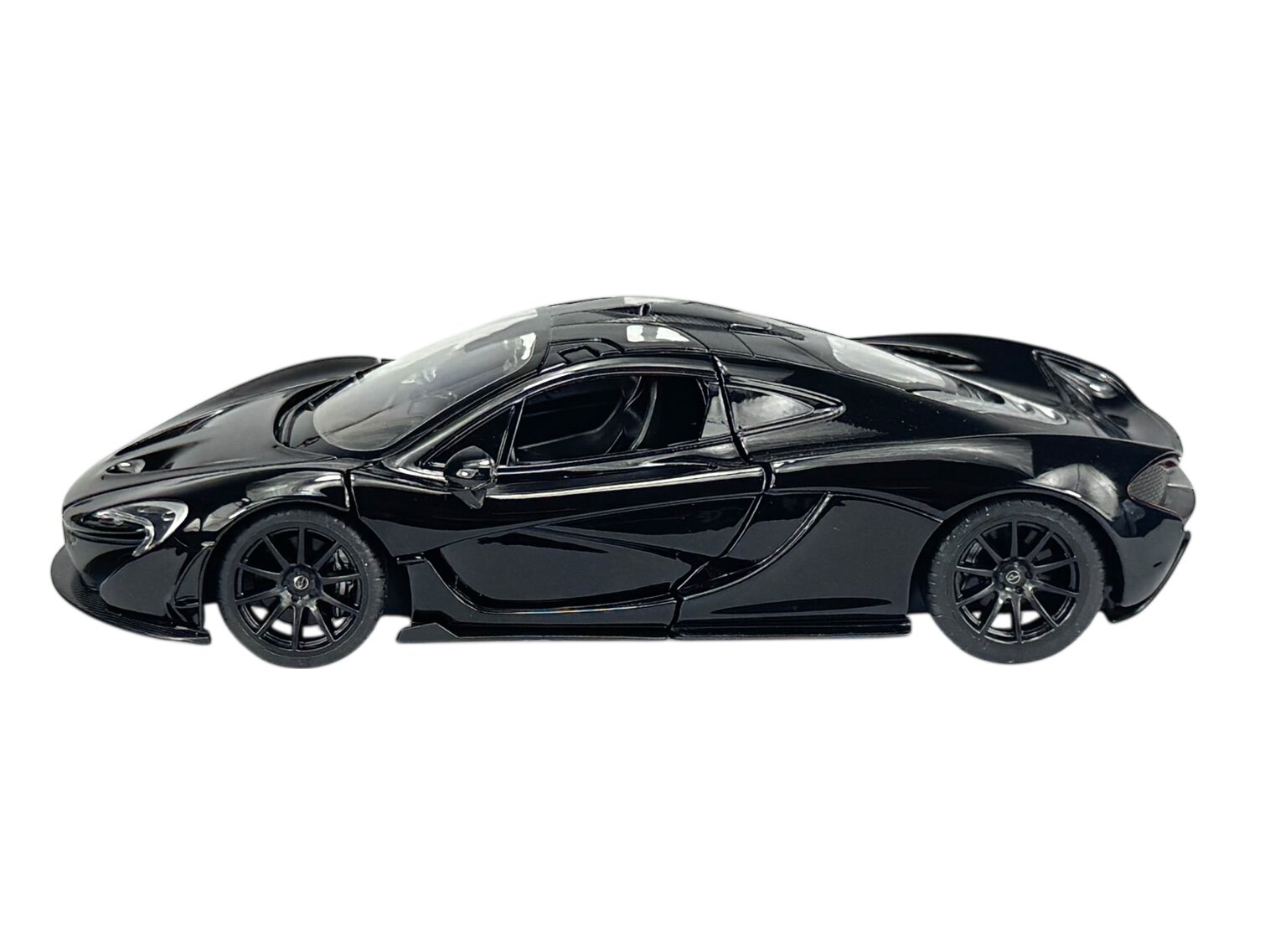 Czarny model samochodu sportowego w skali 1:24, o aerodynamicznym kształcie i szczegółowo odwzorowanych elementach nadwozia. Model wykonany jest z metalu i posiada ciemne felgi.