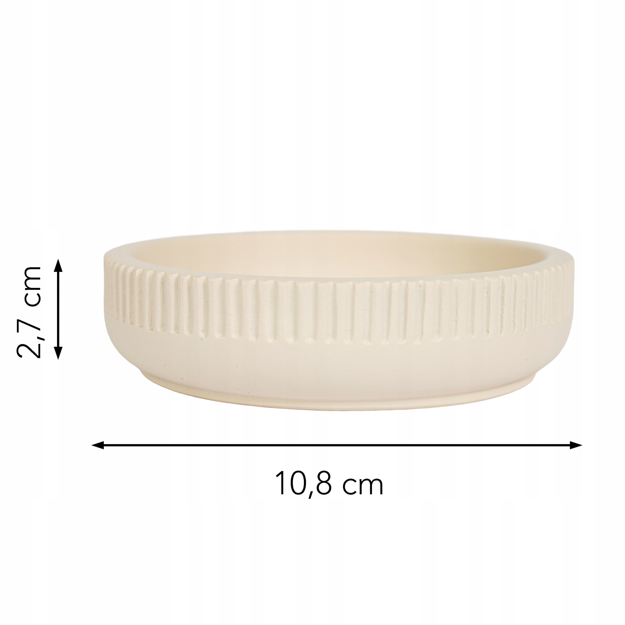 Beżowa mydelniczka o okrągłym kształcie z żłobionym wzorem na zewnętrznej powierzchni. Wymiary: wysokość 2,7 cm, średnica 10,8 cm.