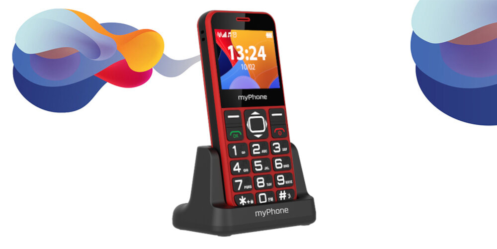 Czerwony telefon z dużymi przyciskami numerycznymi, umieszczony na czarnej podstawce z napisem \'myPhone\'. Na ekranie widoczna jest godzina 13:24 i data 10/02.