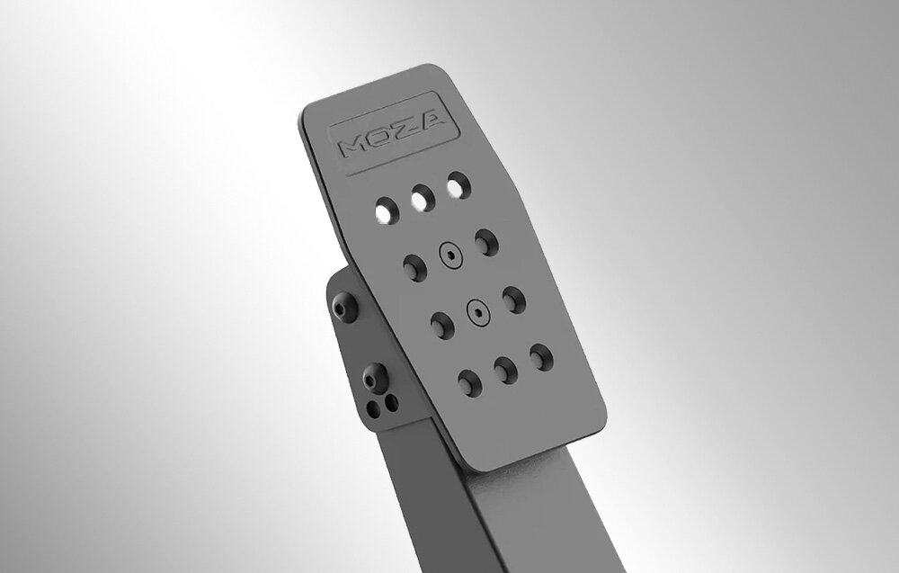 Na obrazie widoczny jest metalowy pedał z otworami, z wygrawerowanym napisem \'MOZA\' na górze. Tło jest jednolite i szare.