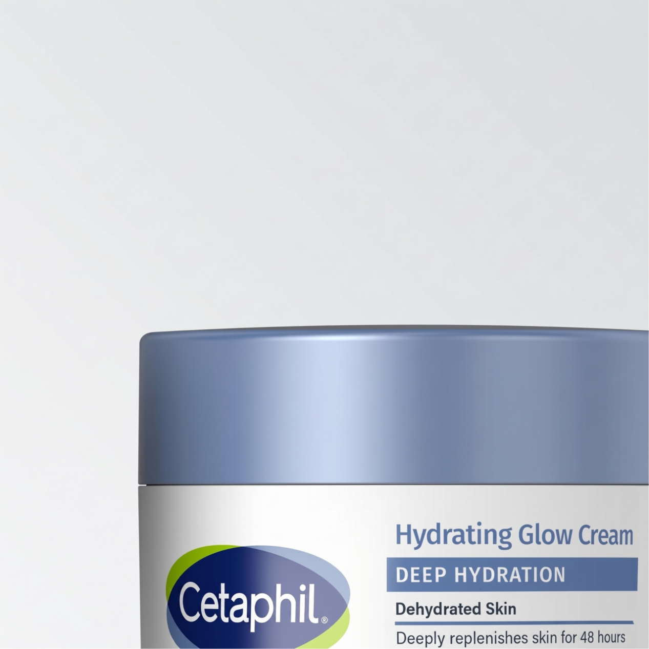 Na obrazie widoczny jest fragment opakowania kremu z niebieską zakrętką i etykietą z napisem \'Cetaphil Hydrating Glow Cream DEEP HYDRATION\'.