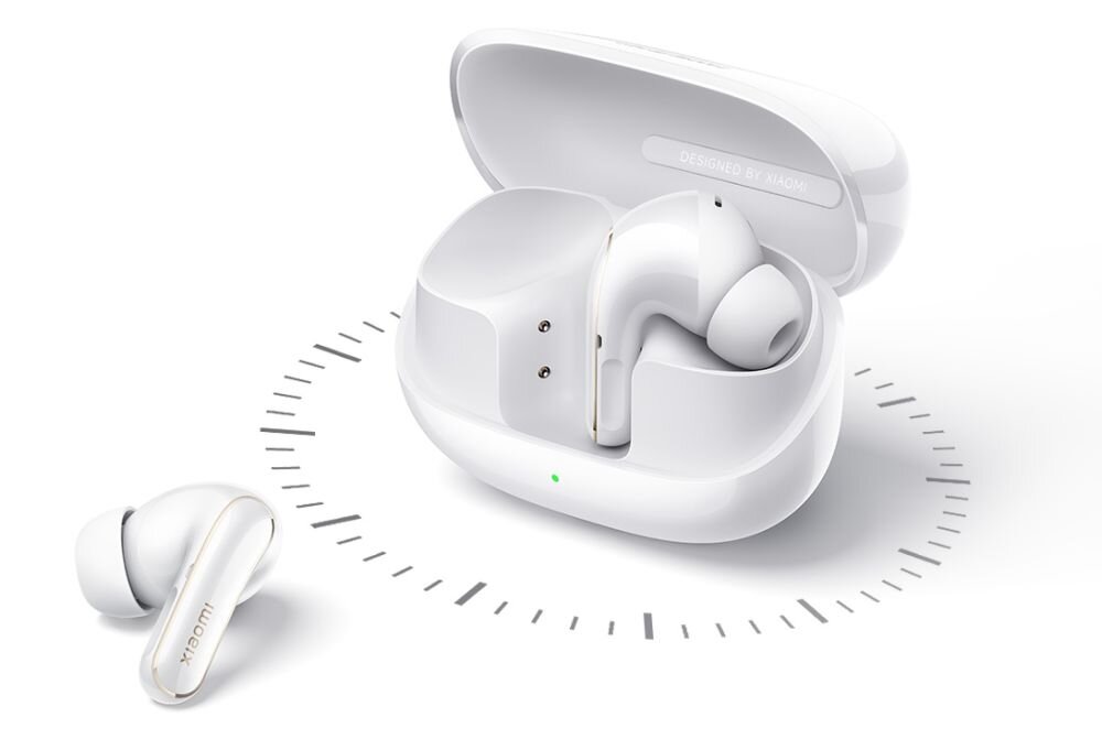 Białe słuchawki dokanałowe w etui ładującym z napisem \'DESIGNED BY XIAOMI\'. Obok etui znajduje się jedna słuchawka, a na etui widoczna jest zielona dioda.