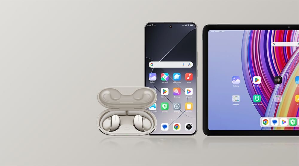 Na obrazie widoczne są beżowe słuchawki douszne w otwartym etui, smartfon z wyświetlonymi ikonami aplikacji oraz tablet z kolorowym ekranem. Wszystkie urządzenia są ustawione na jasnym tle.