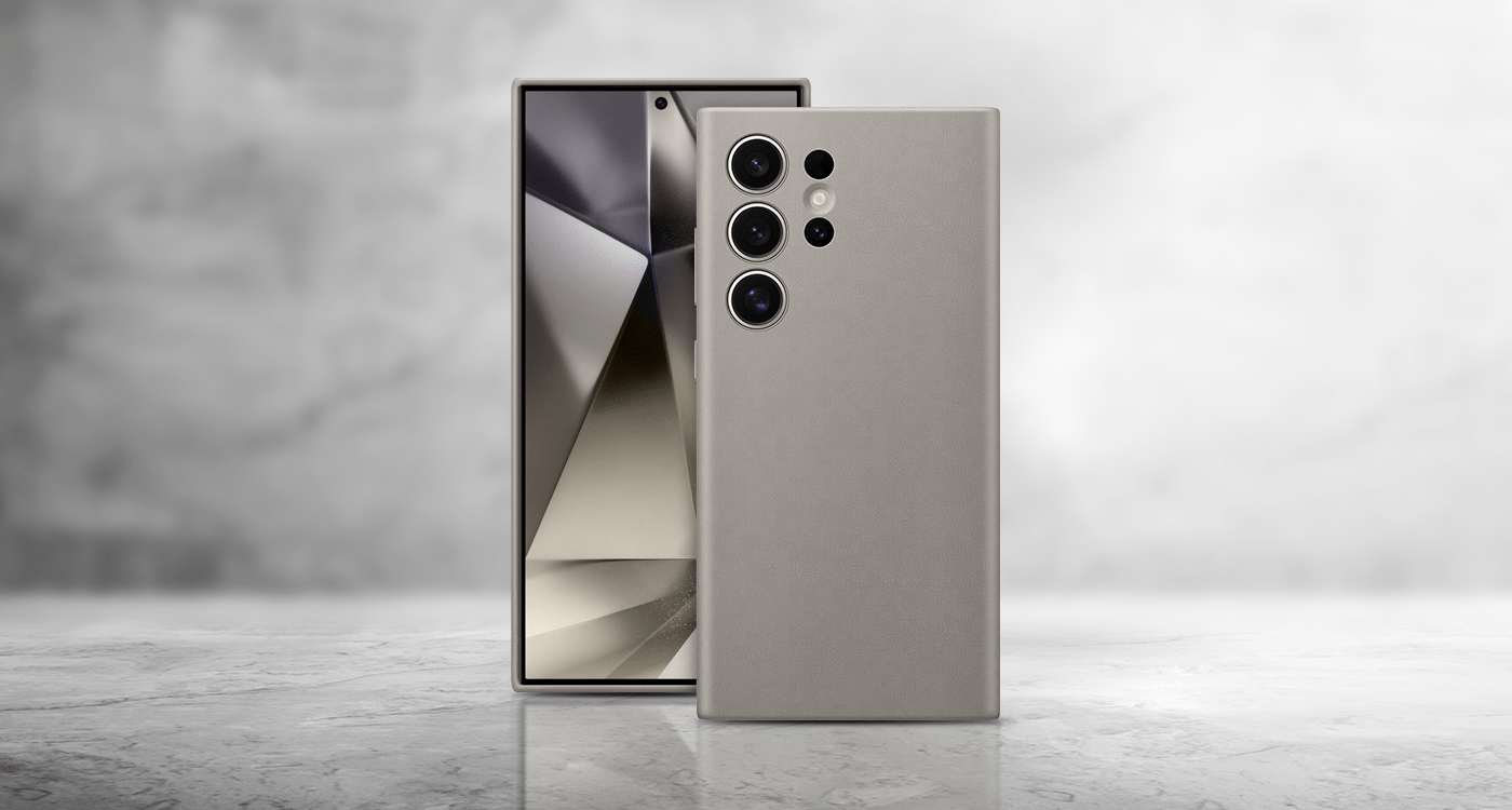 przyjazne dla środowiska wegańskie etui do telefonów Galaxy z serii S24 dostępne w Media Expert Na obrazie widoczne jest ciemnoszare etui na telefon z trzema otworami na aparaty fotograficzne. W tle znajduje się telefon z wyświetlaczem pokazującym abstrakcyjny wzór.