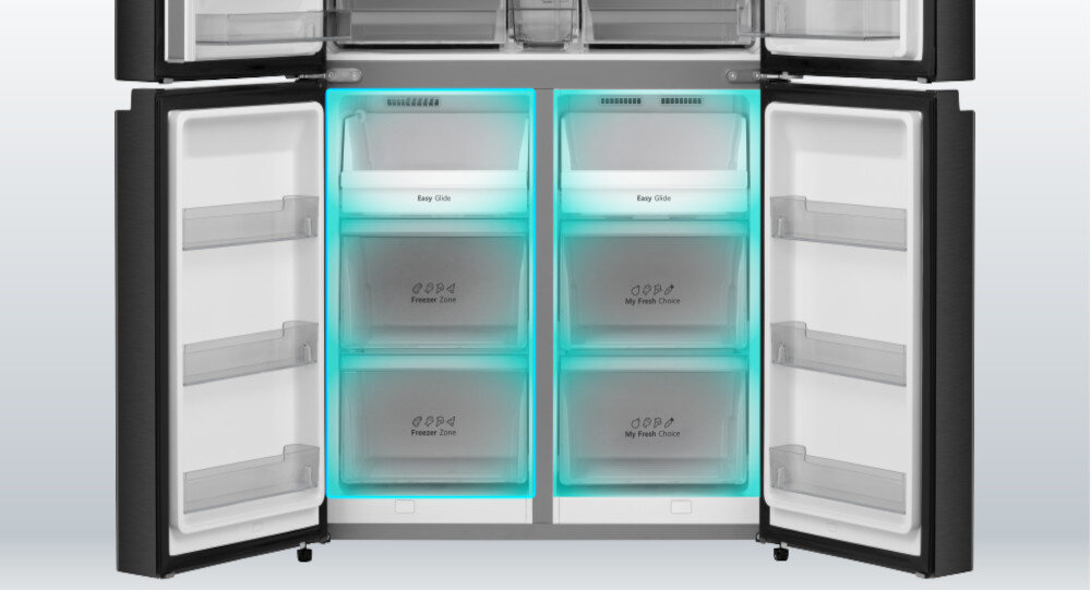 Otwarta lodówka z czterema podświetlonymi na niebiesko szufladami, z napisami \'Easy Slide\', \'Freezer Zone\' i \'My Fresh Choice\'. W drzwiach znajdują się półki na drobne produkty.