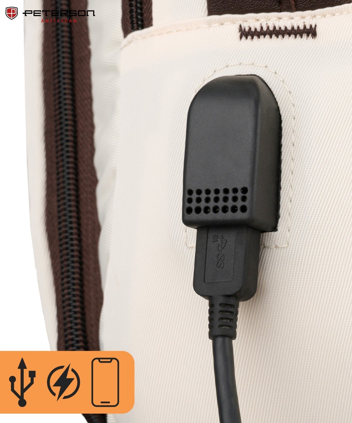 Zbliżenie na beżowy plecak z brązowym zamkiem błyskawicznym i czarnym portem USB. W lewym górnym rogu widoczne jest logo \'PETERSON\'.