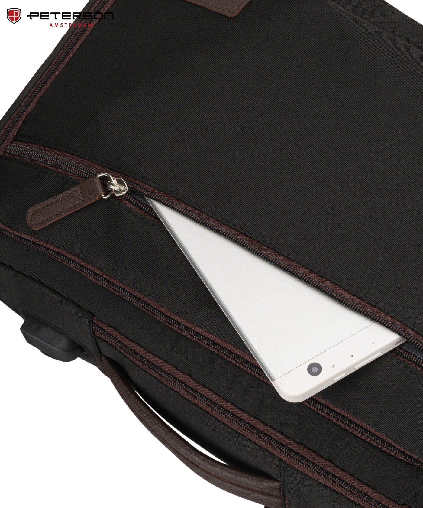 Czarny plecak z brązowymi zamkami błyskawicznymi, z widocznym logo \'PETERSON AMSTERDAM\' w rogu. W kieszeni plecaka znajduje się biały tablet.