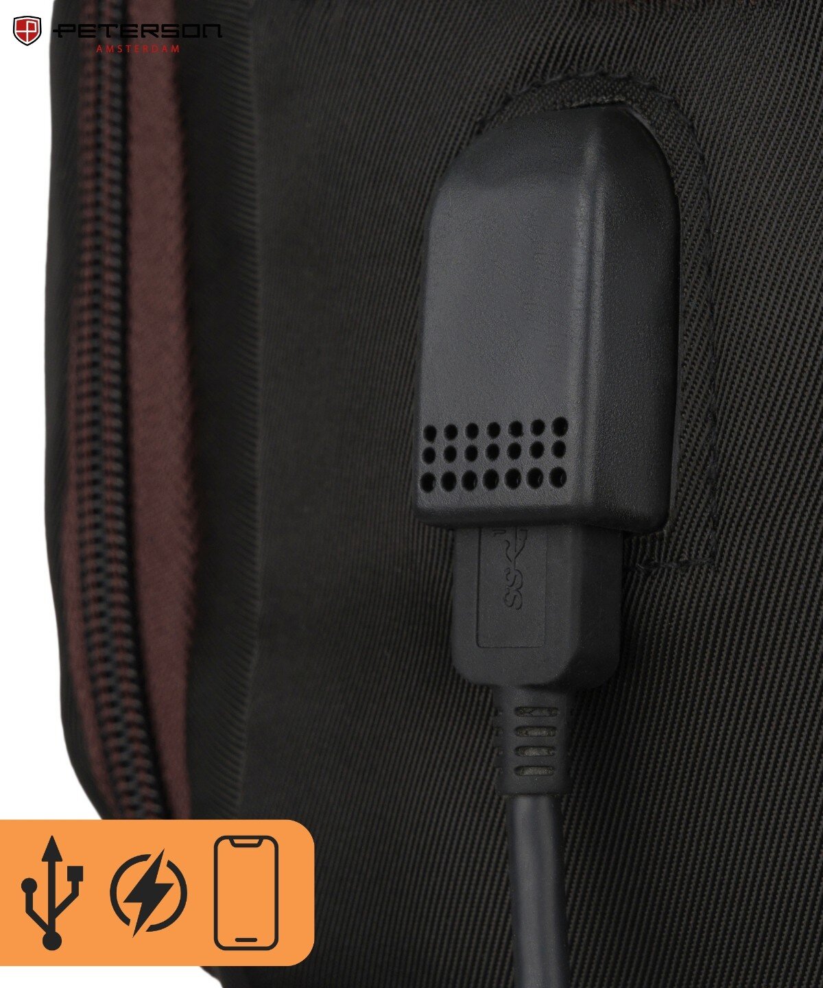 Zbliżenie na czarny port USB wbudowany w materiał plecaka z widocznym logo \'PETERSON\'. W dolnym rogu ikony symbolizujące USB, ładowanie i telefon.