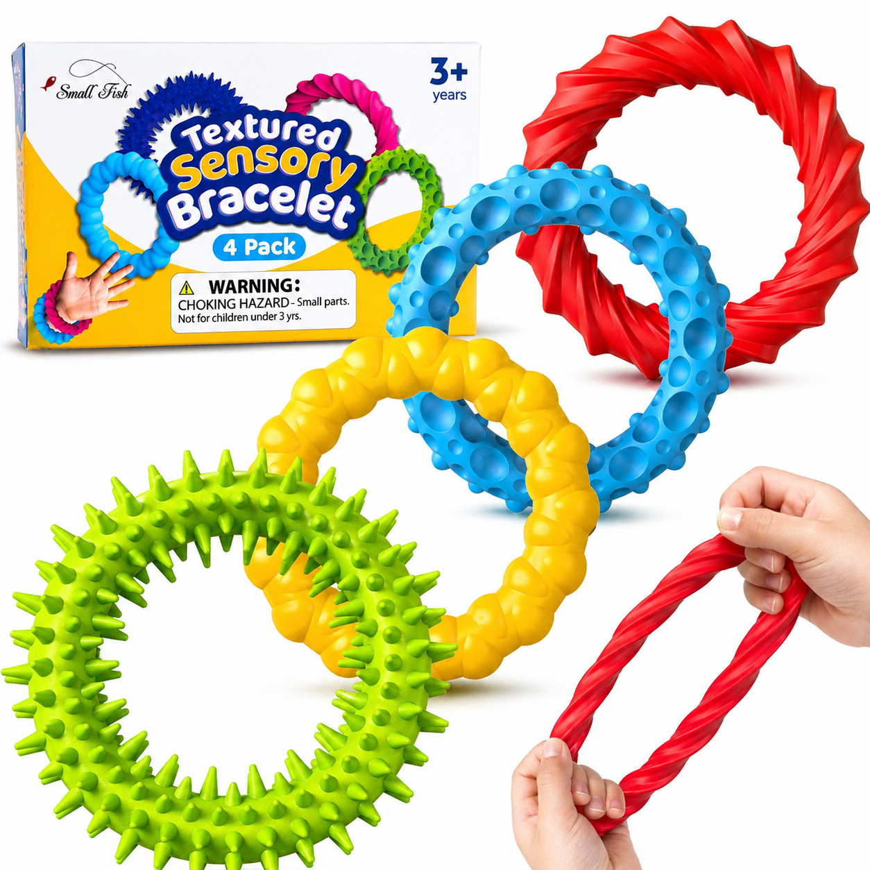 Na obrazie widoczne są cztery kolorowe, sensoryczne bransoletki o różnych fakturach. W tle znajduje się opakowanie z napisem \'Textured Sensory Bracelet 4 Pack\' oraz ostrzeżenie o małych częściach.
