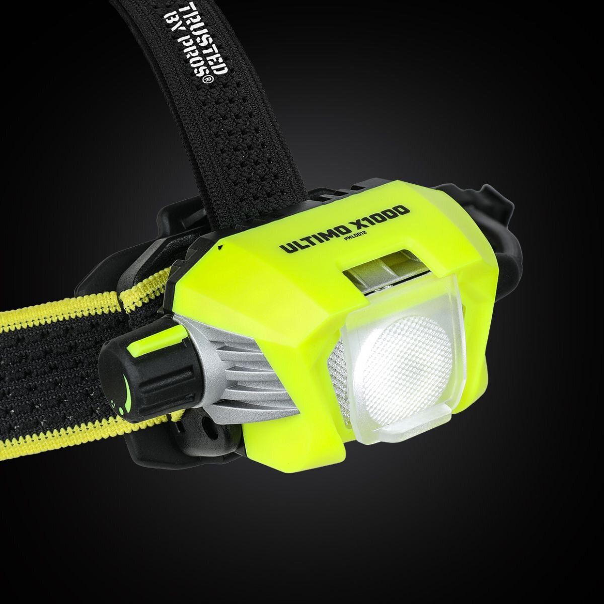 Na obrazie widoczna jest latarka czołowa w kolorze żółtym z czarnymi elementami, z napisem \'ULTIMO X1000\' na obudowie. Latarka jest zamocowana na czarnym pasku z żółtym akcentem.