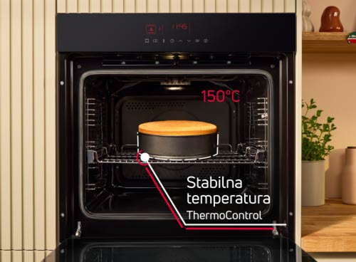 Otwarty piekarnik z ciastem na środkowej półce, na drzwiach wyświetlacz pokazuje 1:46. Na obrazie widoczny jest tekst: \'150°C Stabilna temperatura ThermoControl\'.