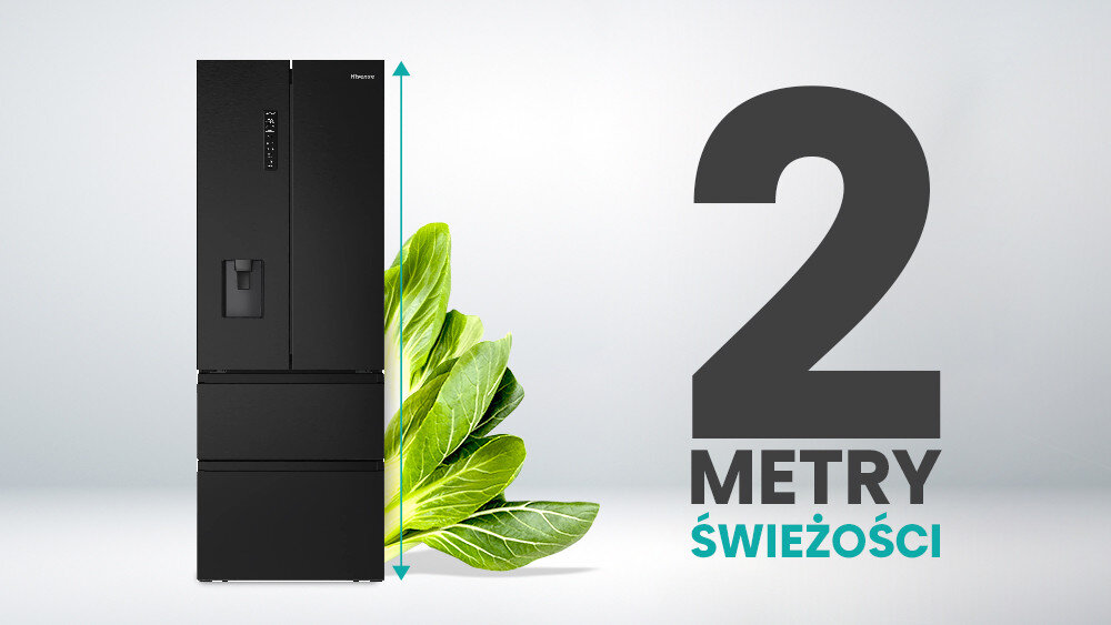 Czarna lodówka z dozownikiem wody i panelem sterowania na drzwiach, obok której znajduje się zielony liść. Obok lodówki widoczny jest napis \'2 METRY ŚWIEŻOŚCI\'.