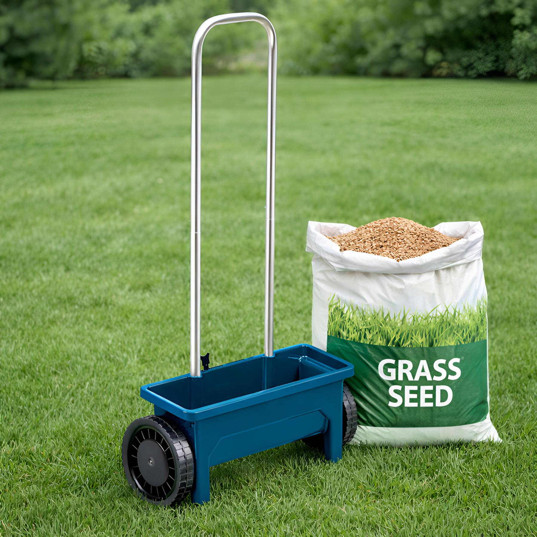 Na trawniku znajduje się niebieski siewnik ręczny z metalowym uchwytem i czarnymi kołami. Obok stoi worek z napisem \'GRASS SEED\' wypełniony nasionami trawy.
