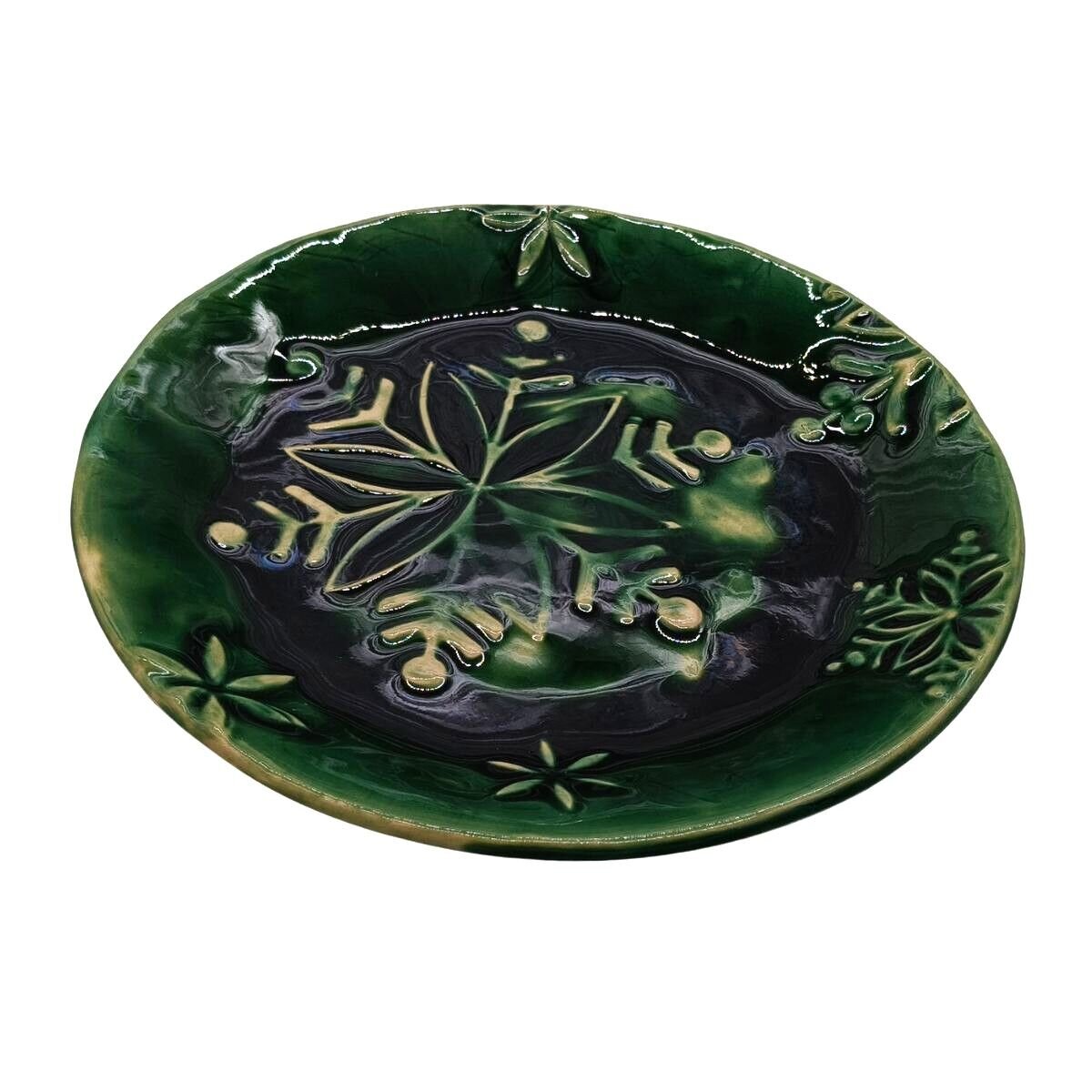 Zielony, ceramiczny talerzyk z motywem liści, szkliwiony i dekoracyjny, o średnicy 17 cm.