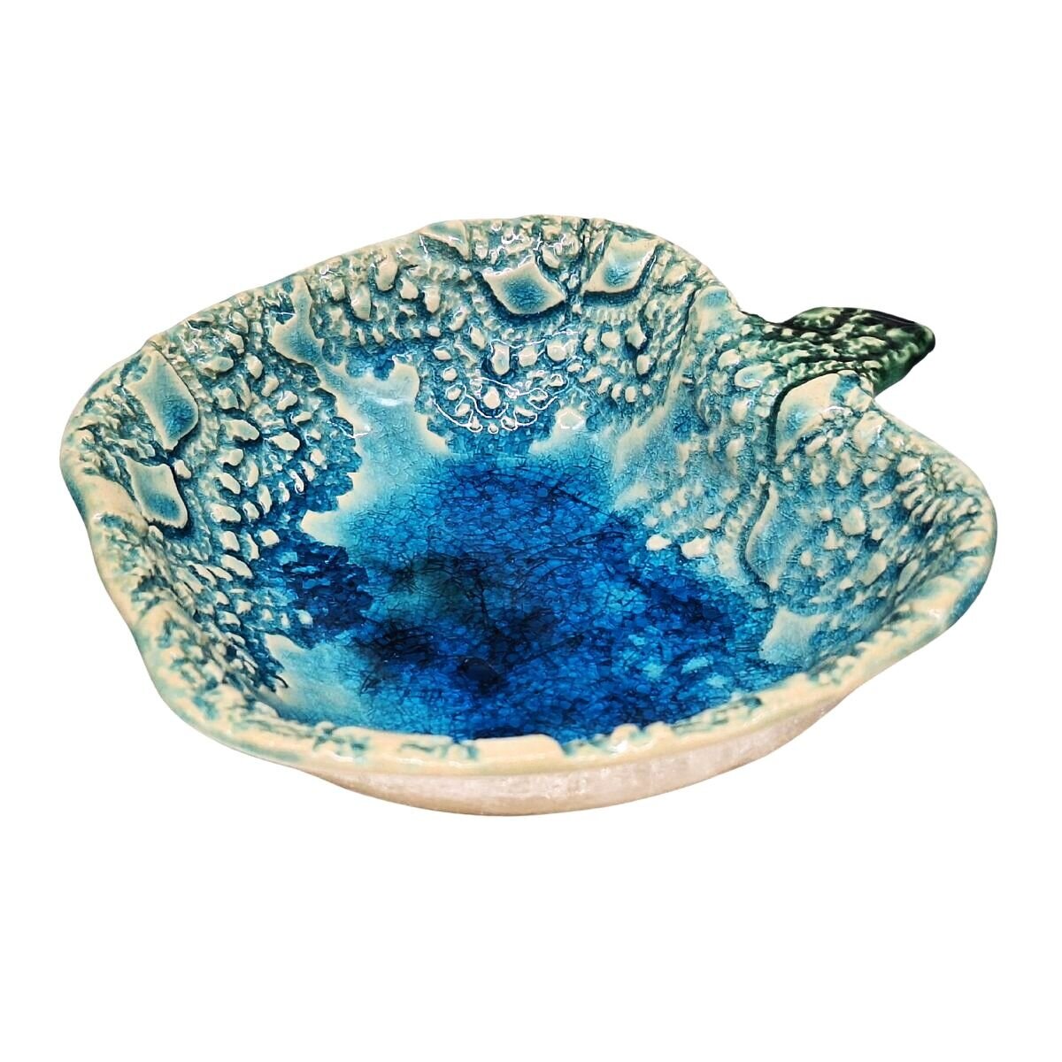 Ceramiczna miseczka w kształcie jabłka, szkliwiona na turkusowo z dekoracyjnym wzorem wewnątrz. Miseczka ma nieregularne krawędzie i ozdobne detale przypominające liście.