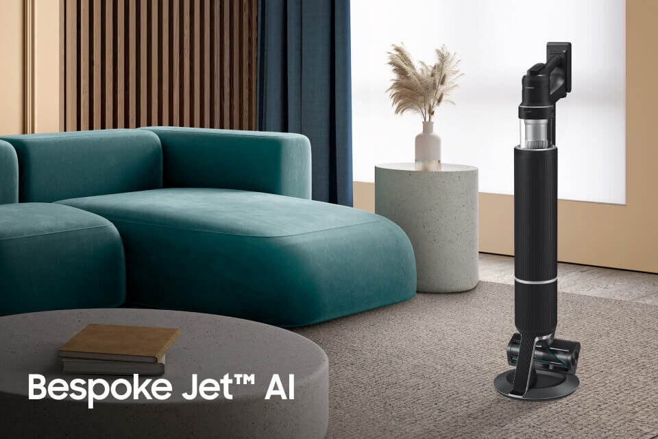 odkurzacz BESPOKE Jet™ AI VS28C9784QK dostępny w Media Expert Na obrazie znajduje się czarny odkurzacz stojący na podłodze w nowoczesnym wnętrzu z turkusową sofą i okrągłym stolikiem. W lewym dolnym rogu widoczny jest tekst: \'Bespoke Jet™ AI\'.