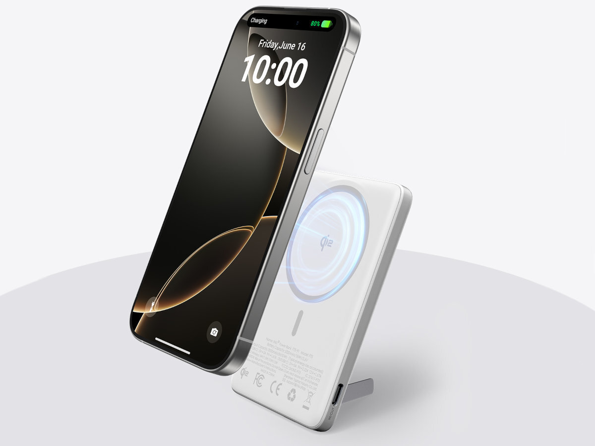 Na obrazie widoczny jest smartfon z wyświetlaczem pokazującym godzinę 10:00 i datę Friday, June 16, umieszczony na białym powerbanku z oznaczeniem Qi. Powerbank ma okrągły wzór na powierzchni i stoi na małej podpórce.