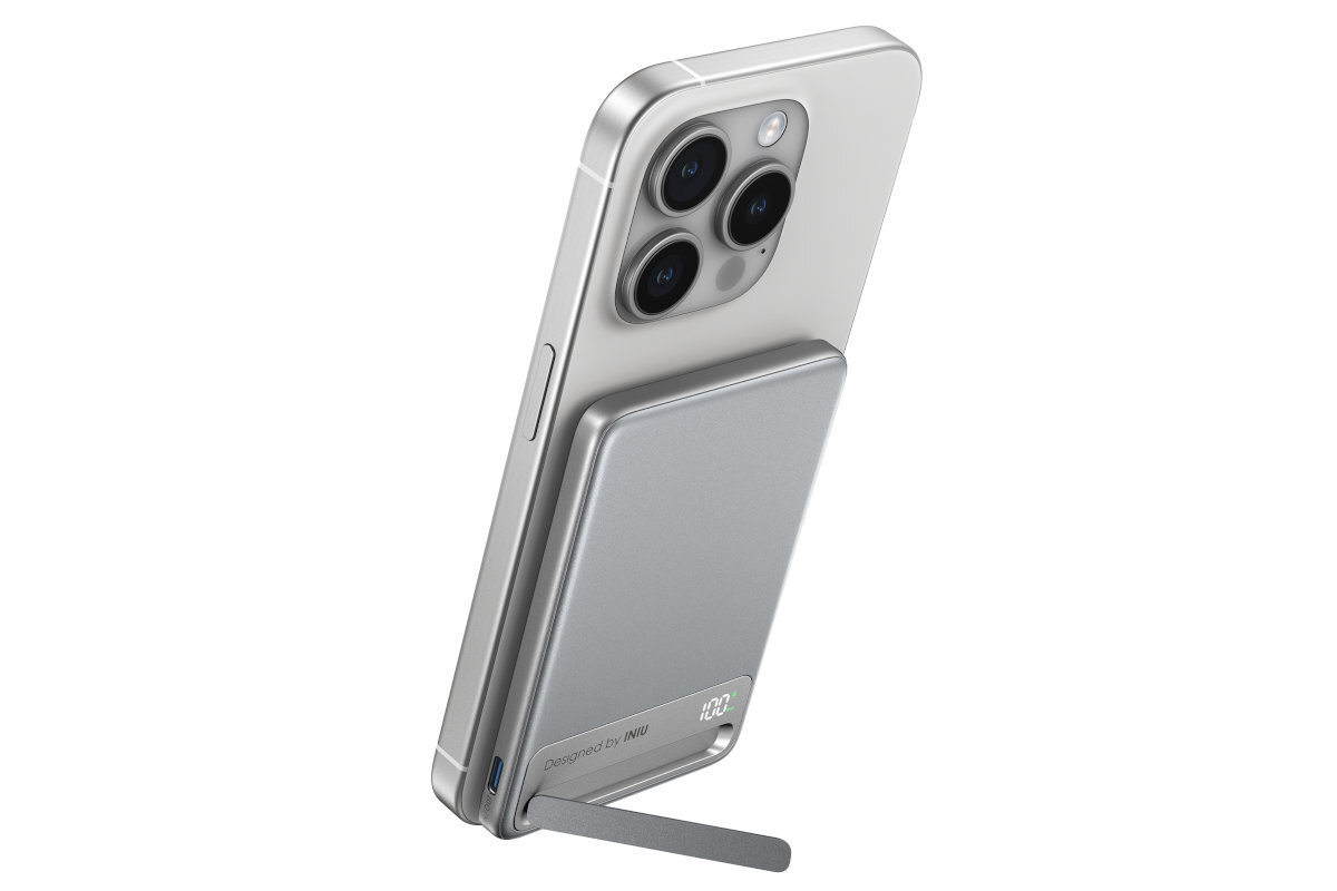 Na obrazie widoczny jest telefon z przyczepionym białym powerbankiem. Powerbank ma napis \'20W\' i jest wyposażony w małą podpórkę.